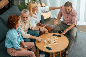 high angle view of smiling old friends playing with wooden blocks at home
